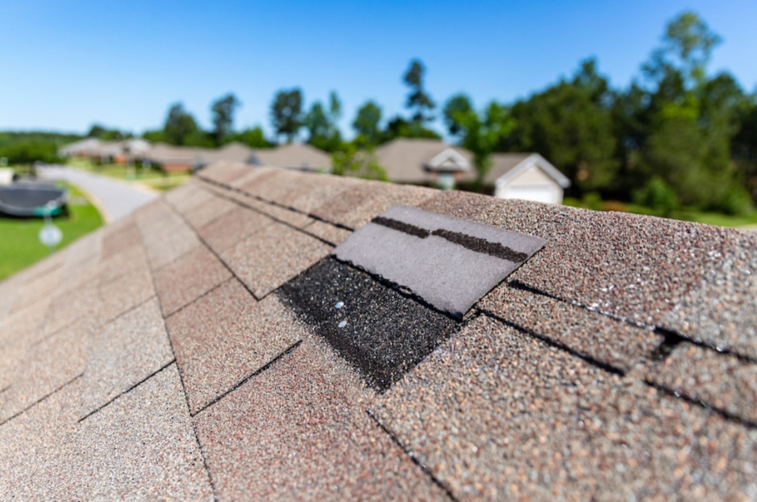 Lifted and cracked asphalt shingle on a roof