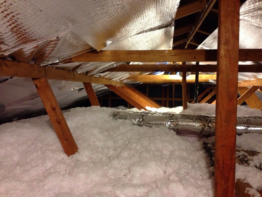 Attic with fibreglass insulation and exposed duct